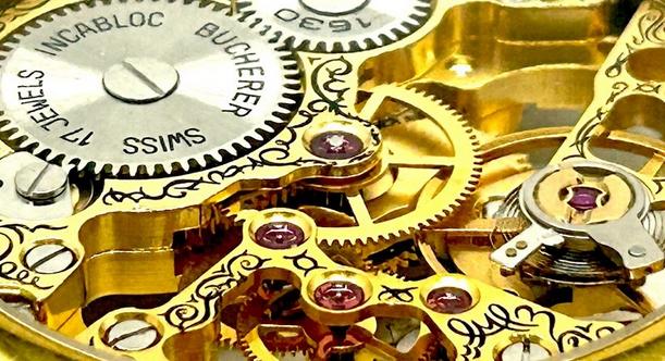 Close-up of a 17-jewel Swiss pocket watch movement showing multiple red ruby jewels set in the gilt bridges